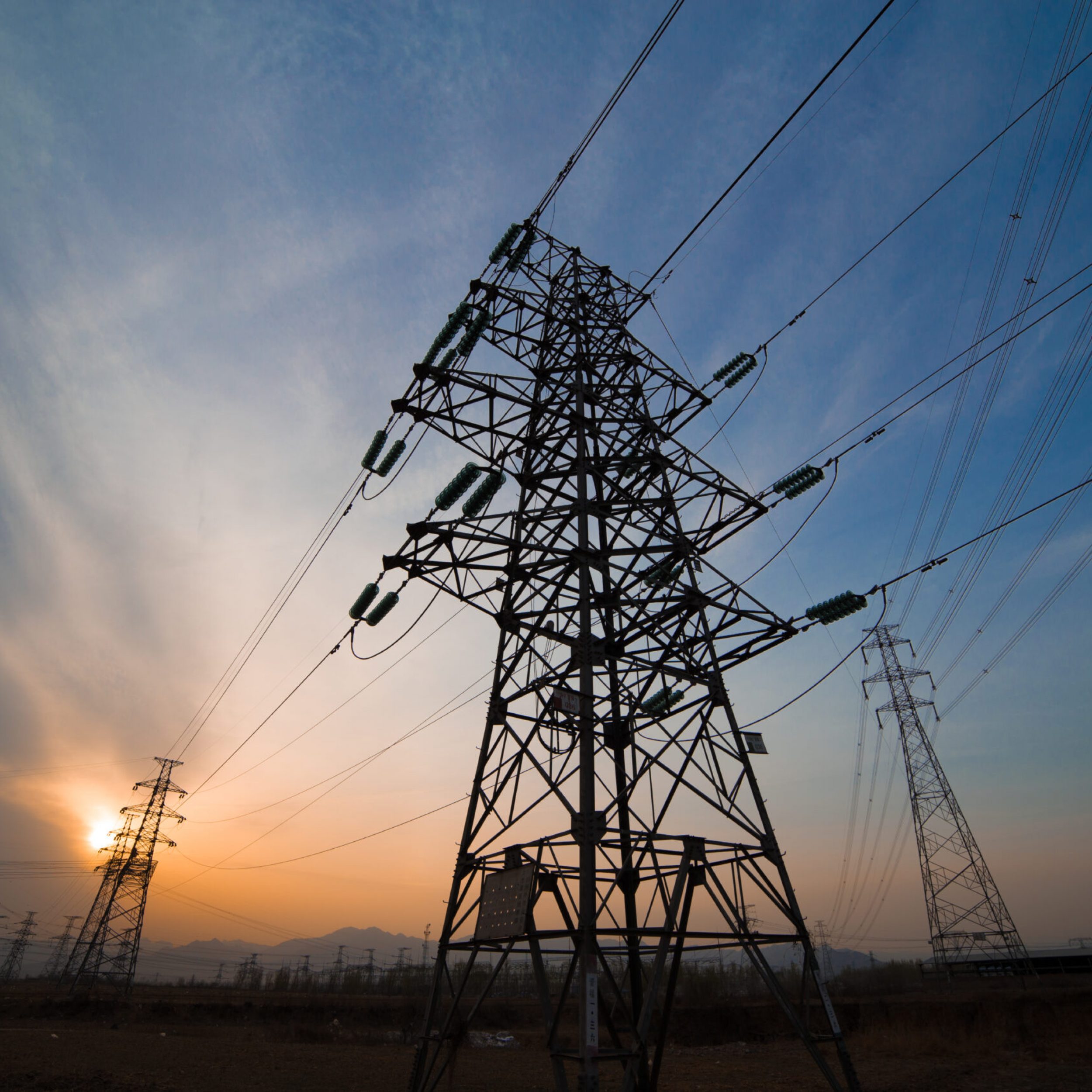 High voltage electricity pylon over sunset.